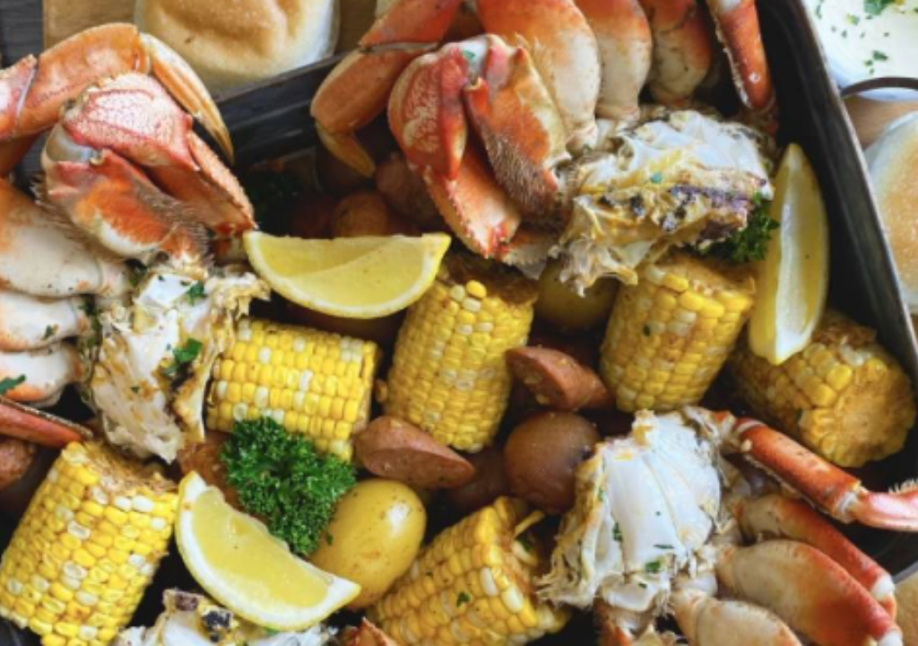a crab boil with corn on the cob, potatoes and lemon