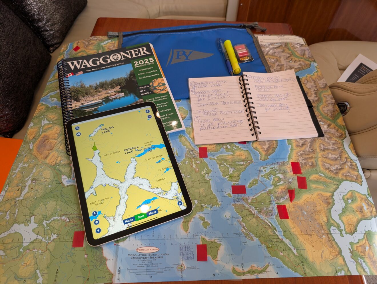 a tablet and notebook on a chart for boat trip planning